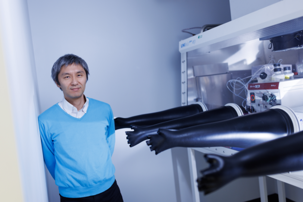 Kenichi Yokoyama stands beside equipment in his lab